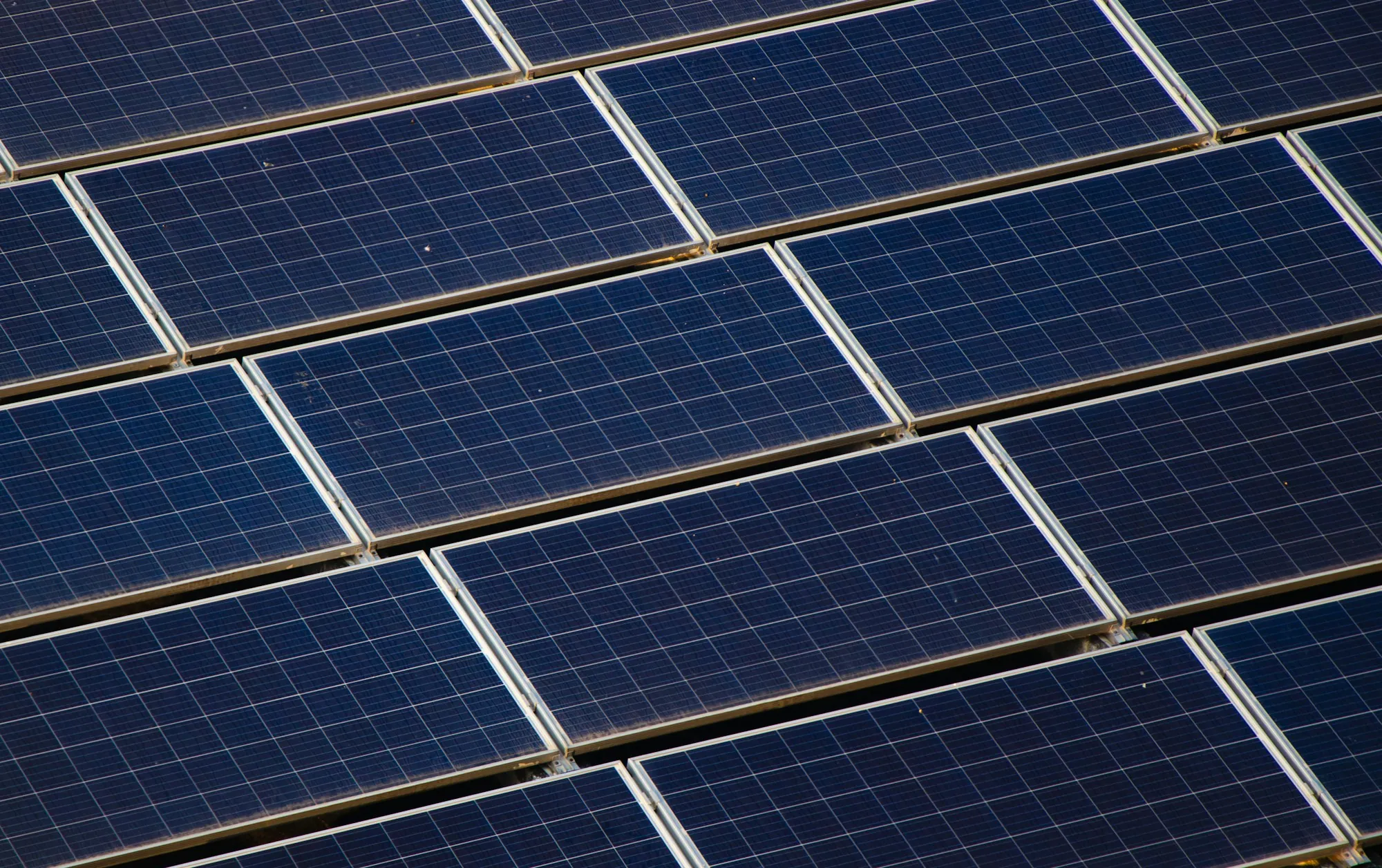 Close-up of overlapping blue solar panels on a rack